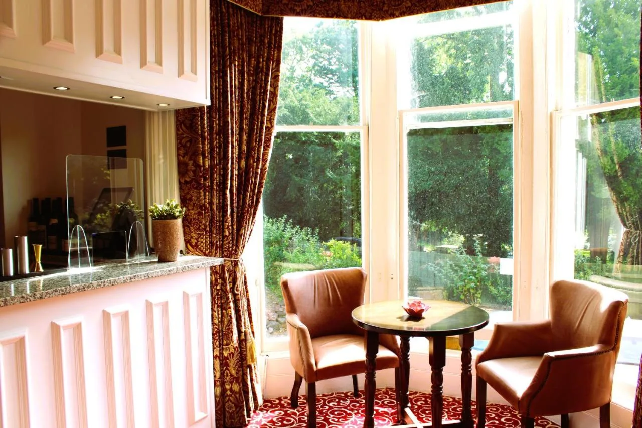 a kitchen with two chairs and a table in front of a window at Victoria Square Hotel Clifton Village in Bristol