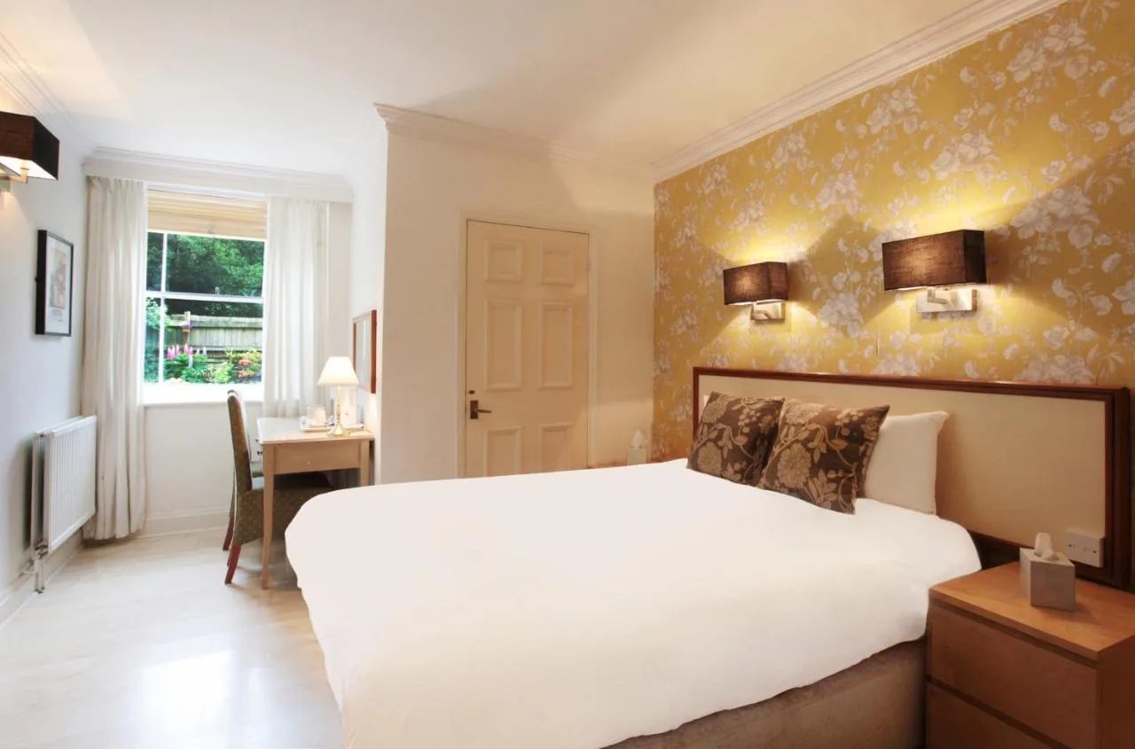 a bedroom with a large white bed and a desk at Victoria Square Hotel Clifton Village in Bristol